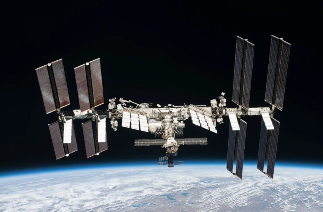 The International Space Station orbiting high above Earth, with solar arrays extended against the blackness of space